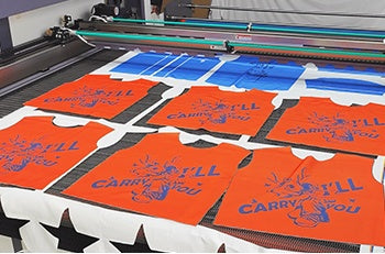 Printed garment panels on the fabric laser conveyor table